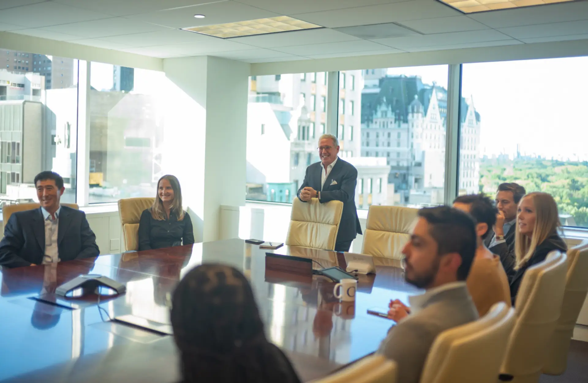 Andrew Farkas standing at the head of a conference room table in a meeting with associates