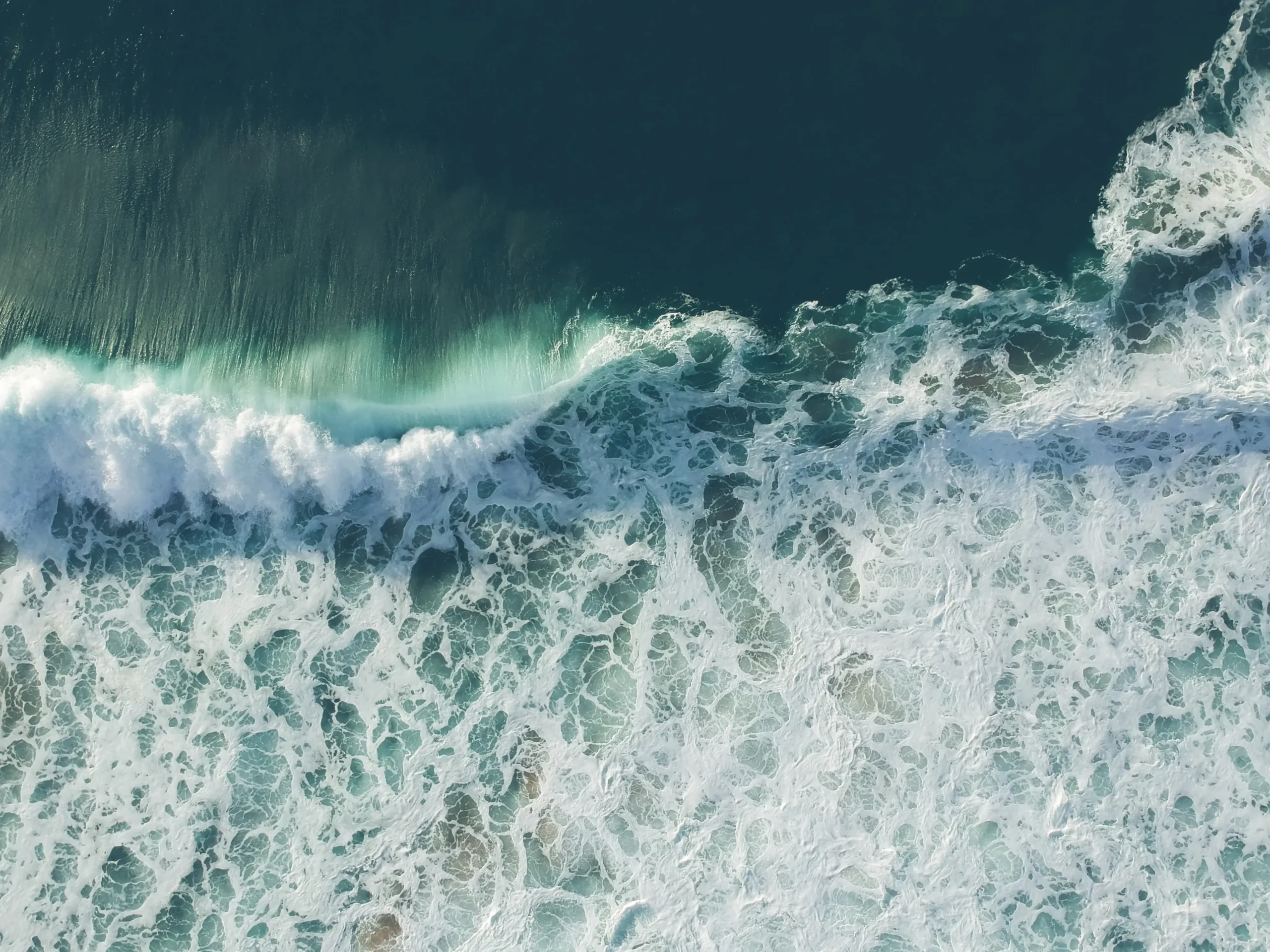 aerial view of ocean waves crashing